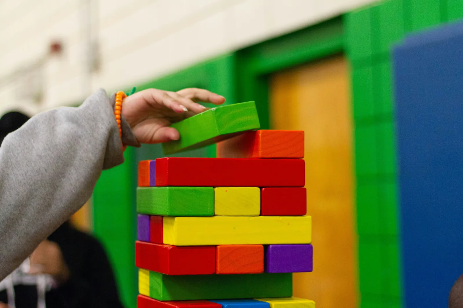 Enfant construisant une tour avec des blocs en bois colorés