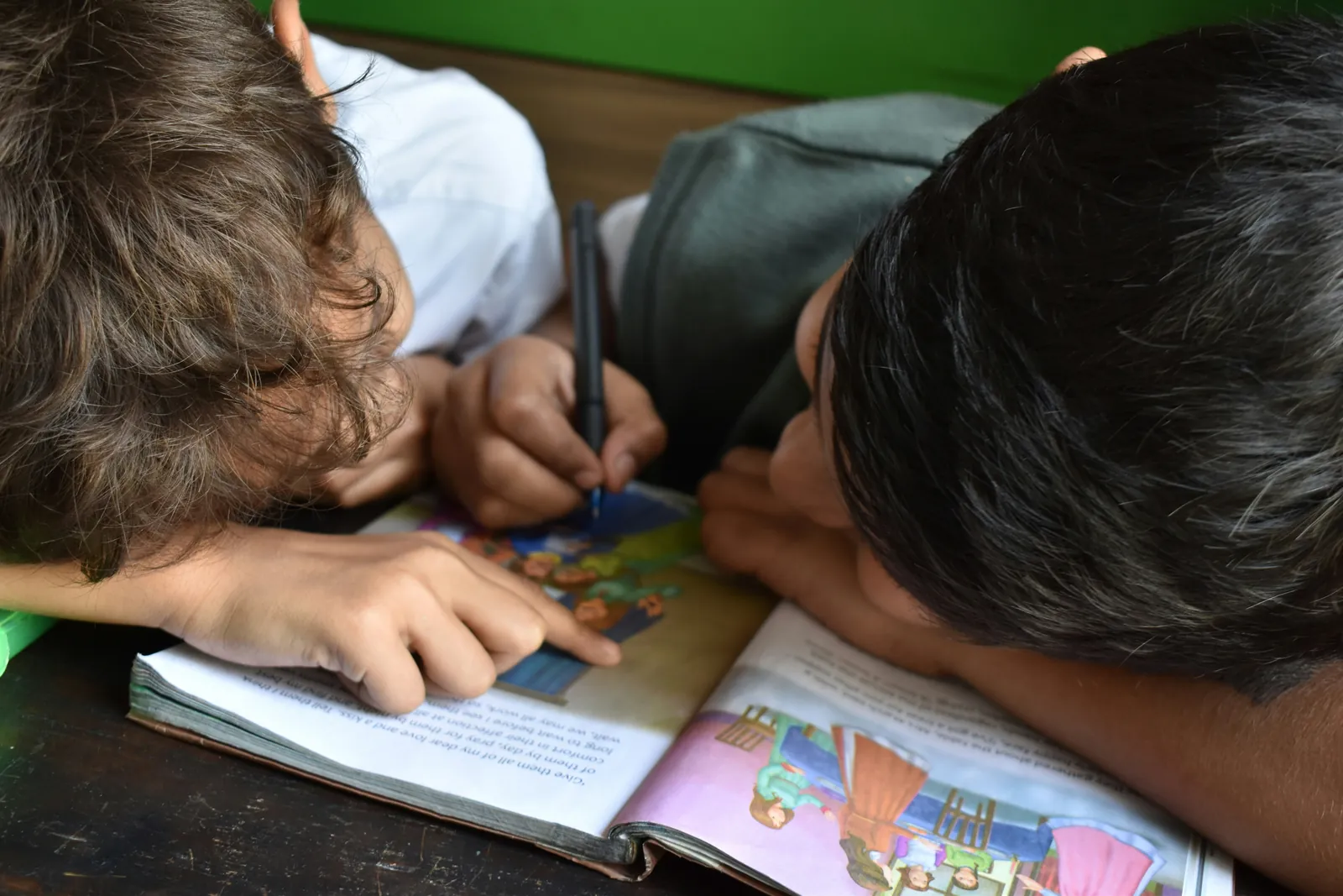 Deux enfants découvrant un livre d'histoires ensemble à la crèche Al Hay Al Jadid